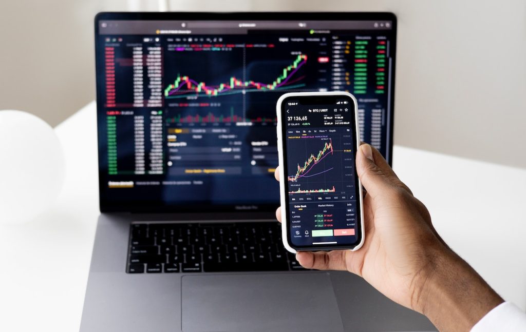 phone and laptop screen showing investors portfolio.